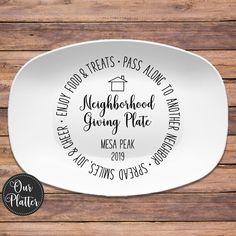 a white plate with the words neighborhood giving plate printed on it, and a wooden background