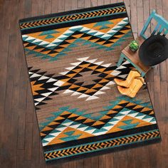 a brown and blue rug sitting on top of a wooden floor next to a chair