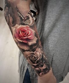 a person with a tattoo on their arm holding a rose and butterfly in front of them