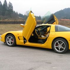 a yellow sports car with its doors open