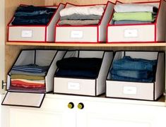 an organized closet filled with folded clothes and storage bins on the bottom shelf next to drawers