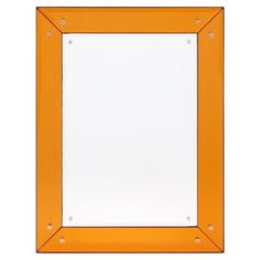 an orange framed mirror with rivets on the edges and bottom, against a white background