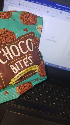 a bag of chocolate cookies sitting on top of a laptop computer