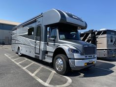 an rv parked in a parking lot next to two other motorhomes and trailers