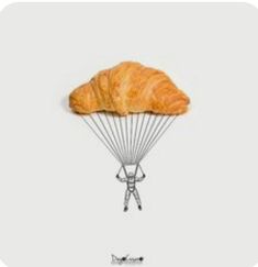 a croissant with a person holding on to it's back as if they were parachuting