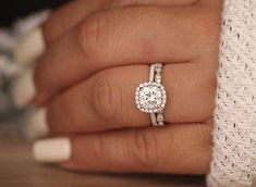 a woman's hand with a diamond ring on it