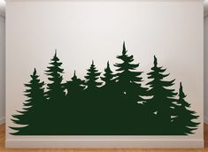 a wall that has some trees on it in front of a white wall with wood flooring