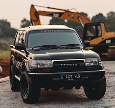 an suv parked in front of a construction vehicle