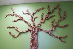 a sculpture of a tree on a green wall