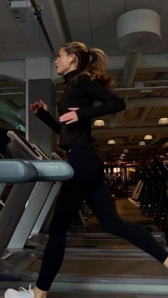 a woman running on a treadmill in a gym