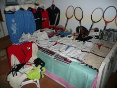 there are many tennis rackets on the table and in front of it is a bed