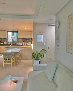 a living room filled with furniture next to a kitchen and dining area in a home