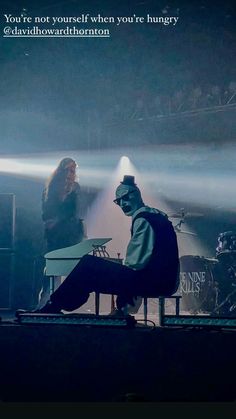 a man sitting on top of a stage next to a woman