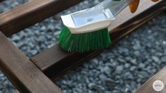 a green brush sitting on top of a wooden bench