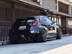 a black sports car parked in front of a building