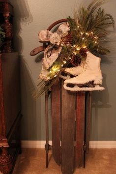 a wooden trash can with christmas decorations and lights on it's top, in front of a wall