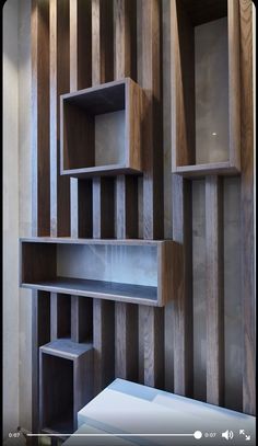 an empty shelf in the corner of a room with striped wallpaper and wooden paneling