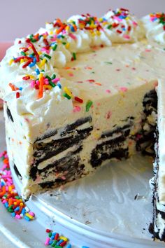 a cake with white frosting and colorful sprinkles on the top is cut in half