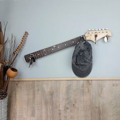 a hat is hanging on the wall next to a guitar