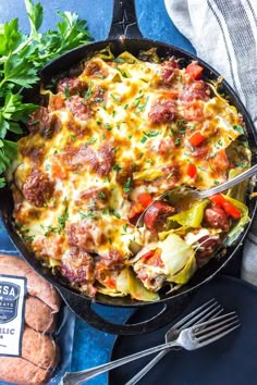 a casserole with meat and vegetables in a skillet on a blue cloth