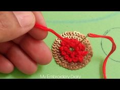 someone is making a small ornament with red thread