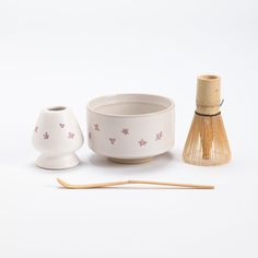 two bowls and a bamboo stick on a white surface