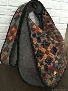 a bag sitting on top of a wooden table next to a white brick wall and floor