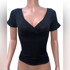 Get Ready To Elevate Your Wardrobe With This Black Fitted Stretchy Tank Top. The Low-Cut V-Neckline And Faux Wrap Design Creates A Flattering Cleavage While The Slim Fit Showcases Your Curves. The Seamless Construction And Stretchy Material Add Comfort And Flexibility To Your Everyday Wear, Making It A Perfect Addition To Your Casual Chic Or Party Clubbing Outfits. This One Size Tank Top Is Made Of Nylon/Spandex Material And Features Short Sleeves. The Versatile Design And Black Color Make It Ea High Stretch V-neck Tops For Night Out, Stretch V-neck Crop Top For Night Out, Fitted V-neck Top With Medium Bust Support, Black Stretch V-neck Crop Top, Elegant V-neck Crop Top With Built-in Bra, High Stretch Top With Built-in Bra For Night Out, Fitted Low-cut Top For Night Out, Black Seamless V-neck Top, Chic Low-cut Top With Built-in Bra