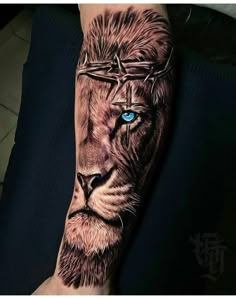 a man's arm with a lion tattoo on it and blue eyes in the center