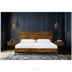 a bed with wooden headboard and foot board in a dark blue room, with two lamps hanging from the ceiling