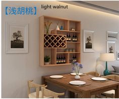 a dining room table with plates and wine bottles on the shelves above it, in front of a couch