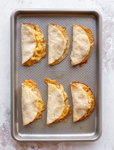 six pita breads sitting on top of a baking pan