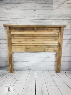 a wooden headboard made out of wood planks on a white painted wall and floor