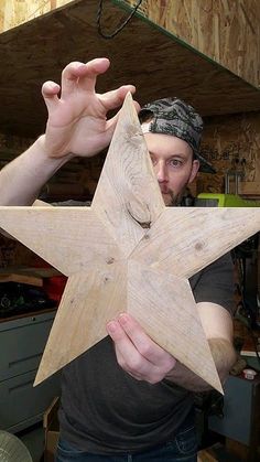 a man holding a wooden star in his hands