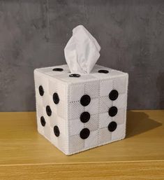 a roll of toilet paper sitting on top of a white cube with black polka dots