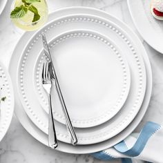 white plates and silverware on a marble table