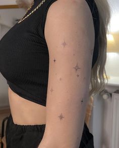 a woman with a small star tattoo on her left arm and right arm behind her back