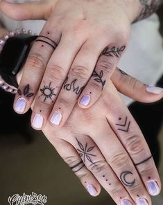 two people with tattoos on their hands holding each other