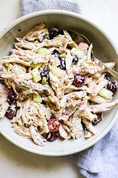 a white bowl filled with chicken salad on top of a table