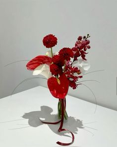 a vase filled with red and white flowers