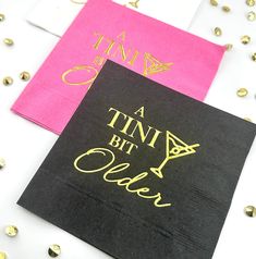 pink and black napkins with gold foil lettering on them that say, a tint bit older