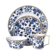 a blue and white dinner set with flowers on it