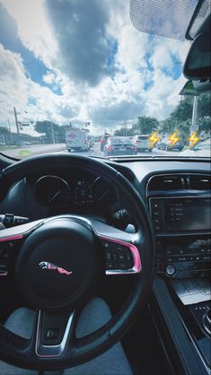 the interior of a car with steering wheel, dashboard and dash board showing various electronic devices