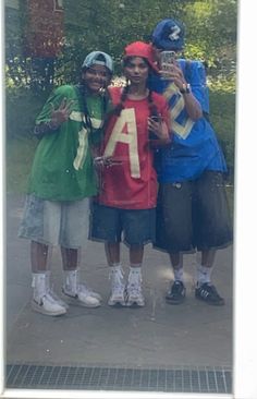 three young men standing next to each other in front of a building with the letter a on it