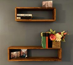 two wooden shelves with books and flowers on them