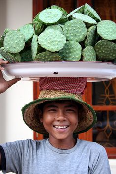 a man with a hat on his head holding a platter full of cactuses