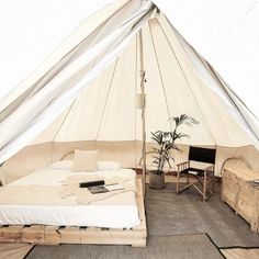 a bed sitting inside of a tent next to a desk