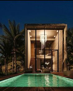 an outdoor swimming pool at night with lights on the side and stairs leading up to it