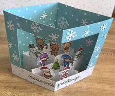 an open gift box with christmas stickers on the front and inside, sitting on a wooden table