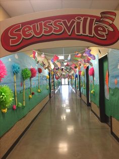 the hallway leading to seusssville's candy shop is decorated with paper pom poms and streamers